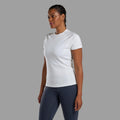 Woman wearing a white t-shirt and dark gray leggings on a gray background